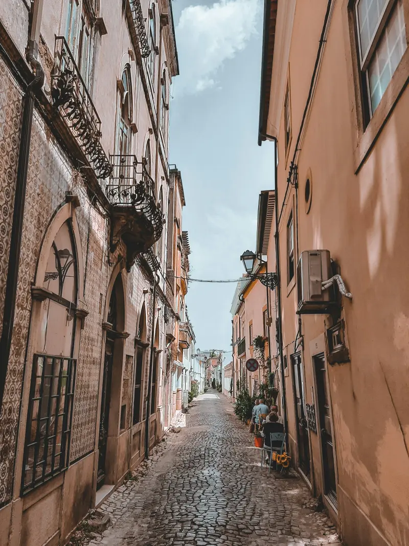 Rua estreita de calçada e fachadas em Tomar